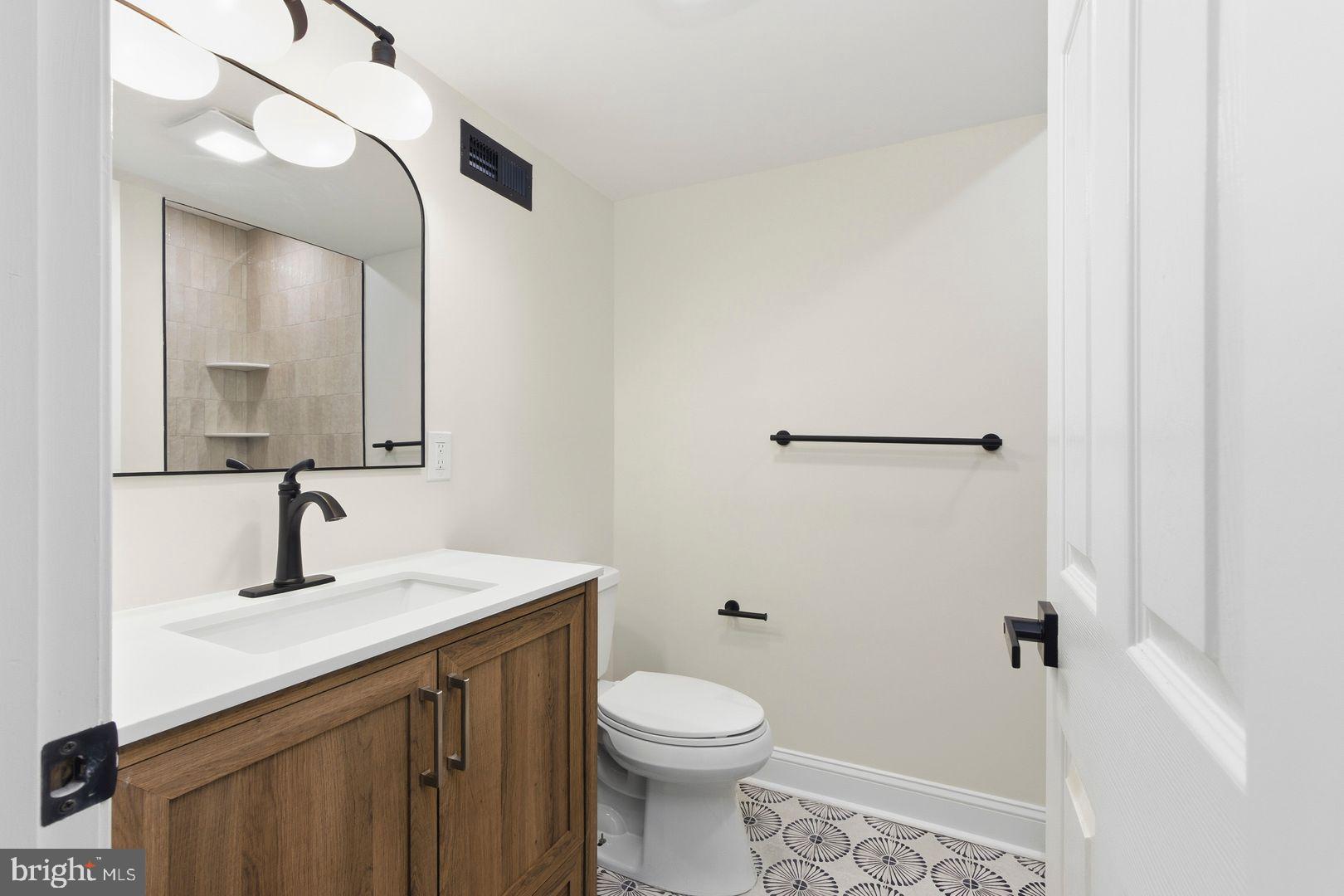 1723-0 Master Street, Unit D Philadelphia, PA 19121 - Photo 7 of 23 a bathroom with a toilet sink and mirror