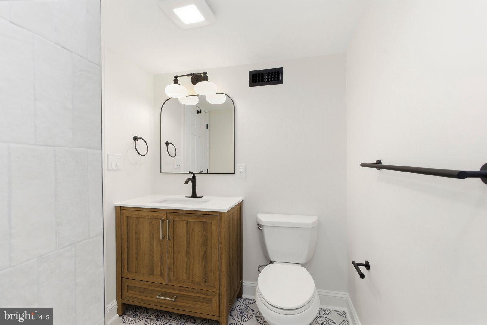 1723-0 Master Street, Unit D Philadelphia, PA 19121 - Photo 8 of 23 a bathroom with a toilet sink and mirror