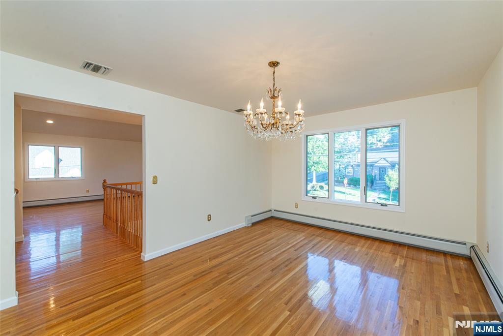 405 Chestnut Street, Unit 1 Ridgefield, NJ 07657 - Photo 14 of 24 a view of an empty room with wooden floor and a window