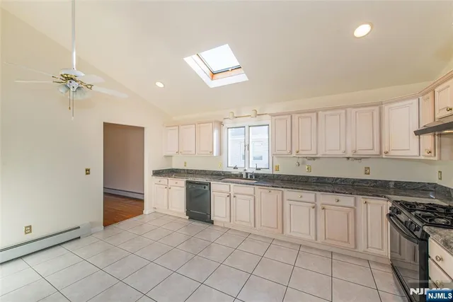 a kitchen with granite countertop white cabinets and appliances