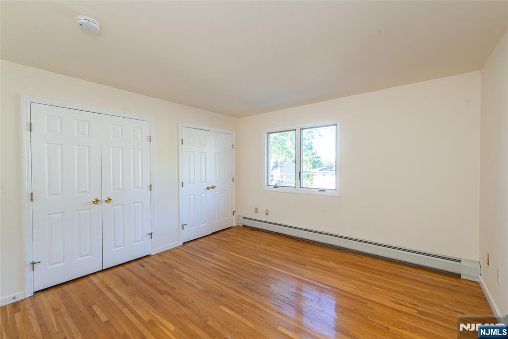 405 Chestnut Street, Unit 1 Ridgefield, NJ 07657 - Photo 19 of 24 a view of empty room with wooden floor and fan