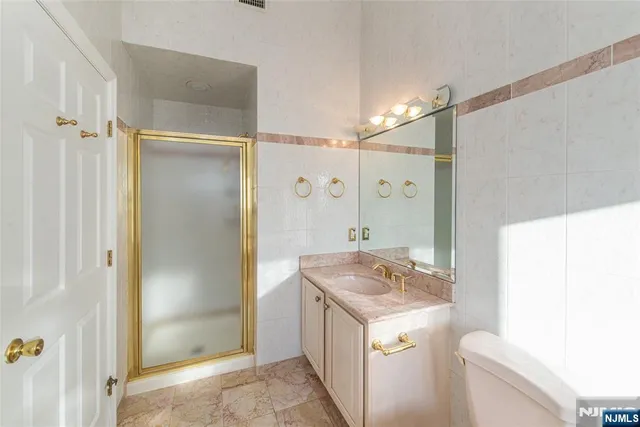 a bathroom with a granite countertop sink a shower and a mirror