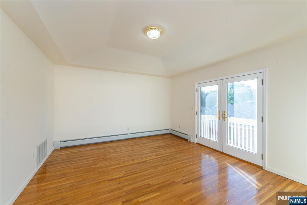 405 Chestnut Street, Unit 1 Ridgefield, NJ 07657 - Photo 21 of 24 a view of an empty room with wooden floor and a window