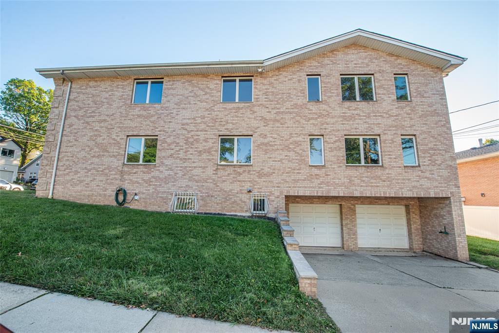 405 Chestnut Street, Unit 1 Ridgefield, NJ 07657 - Photo 24 of 24 a front view of a house with a yard and garage