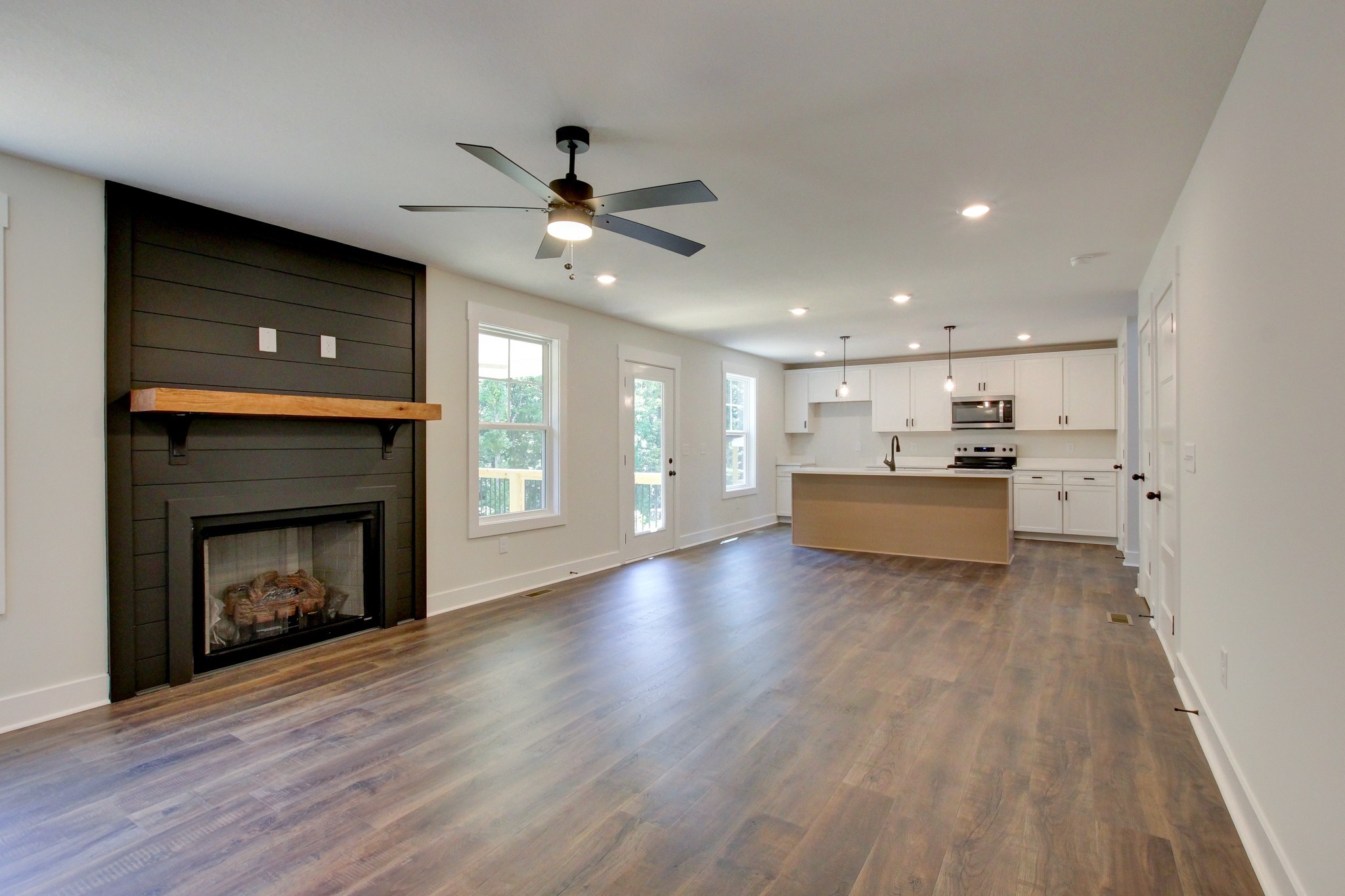 1244 Boulder Pass Road Clarksville, TN 37040 - Photo 13 of 31 a view of a livingroom with a fireplace a ceiling fan a kitchen microwave and a refrigerator