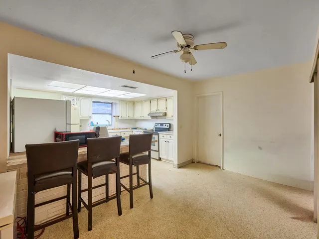 a kitchen with granite countertop cabinets and chair