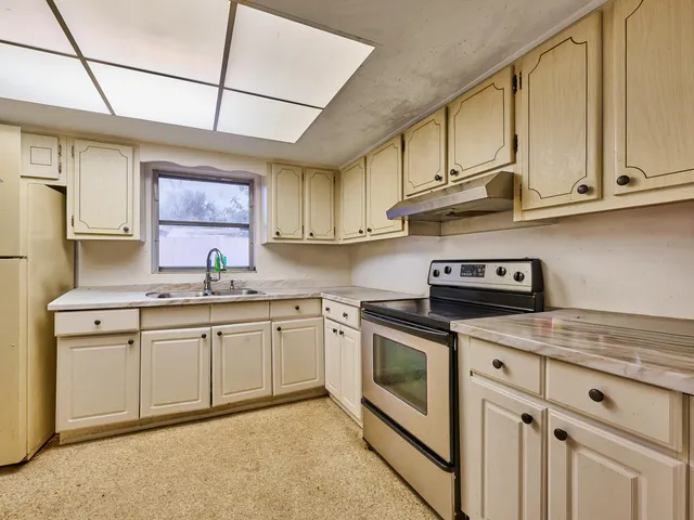 a kitchen with stainless steel appliances granite countertop a refrigerator a sink dishwasher a stove with wooden cabinets