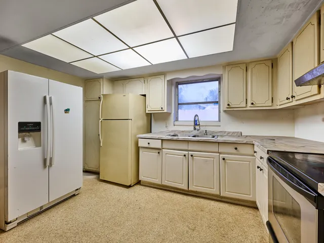 a kitchen with stainless steel appliances granite countertop a sink a stove and cabinets