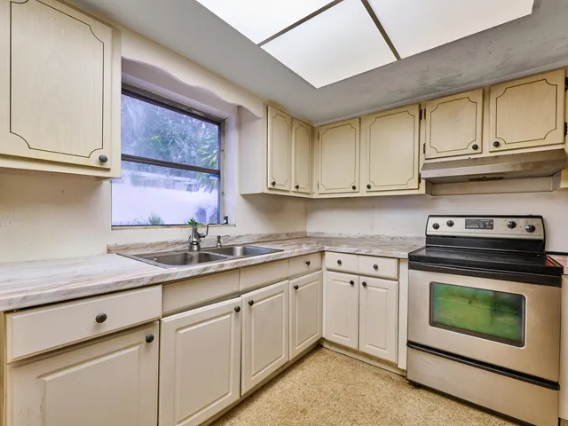 a kitchen with granite countertop white cabinets and stainless steel appliances