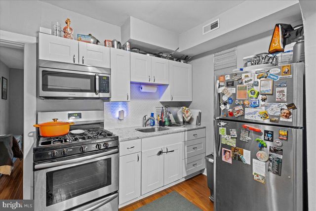 a view of a hallway with a door and wooden floor
