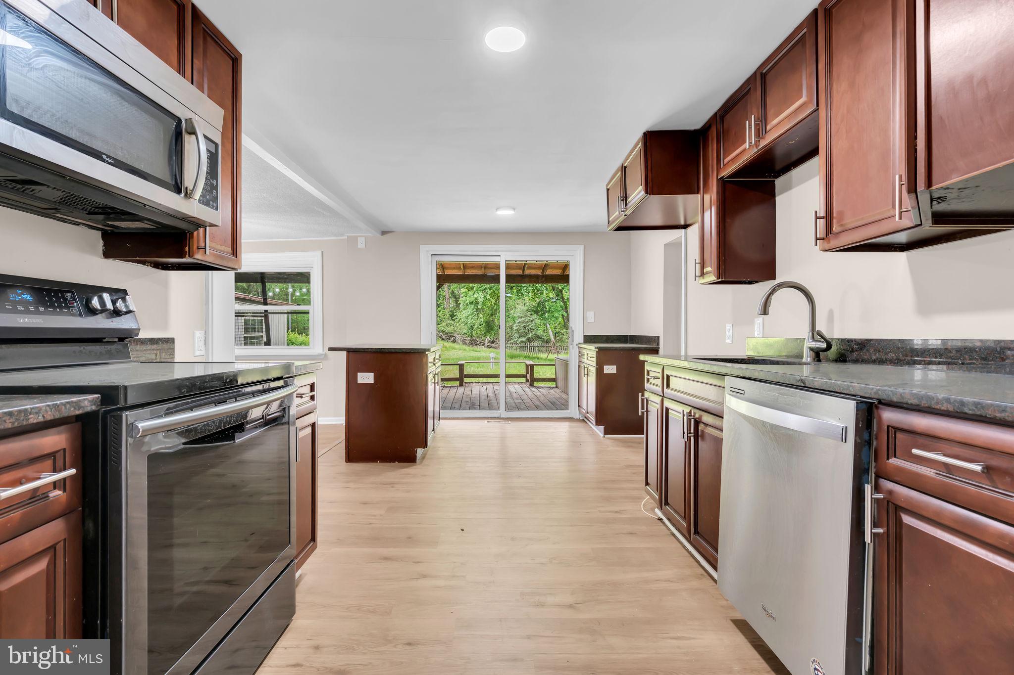 2438 Range Road Browns Mills, NJ 08015 - Photo 13 of 61 a kitchen with stainless steel appliances granite countertop a stove top oven a sink dishwasher a refrigerator and cabinets with wooden floor