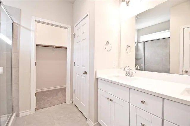 a bathroom with a granite countertop sink a mirror and a shower