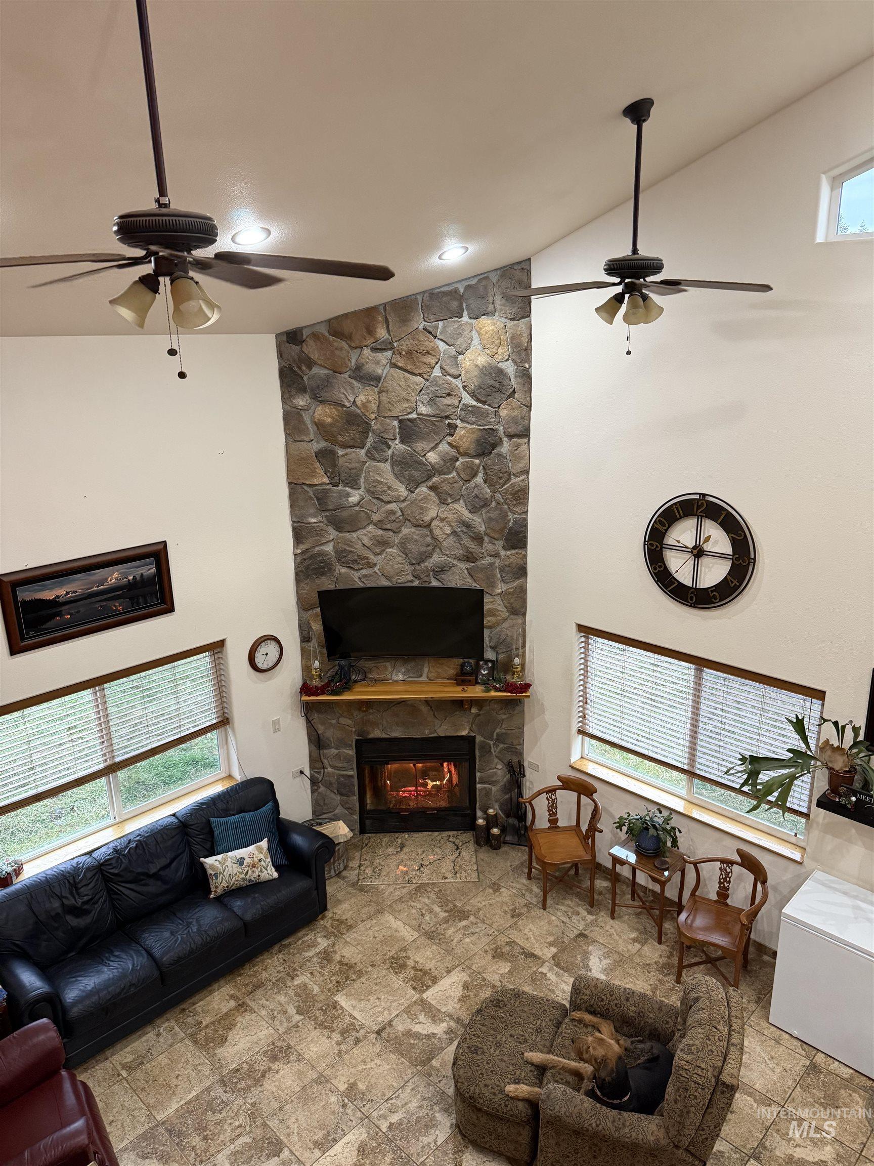 1653 Kidder Ridge Road Kamiah, ID 83536 - Photo 16 of 47 Living area featuring high vaulted ceiling, a ceiling fan, a fireplace, and stone finish flooring