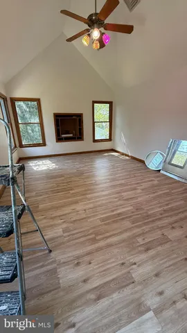 a view of an empty room with wooden floor and closet