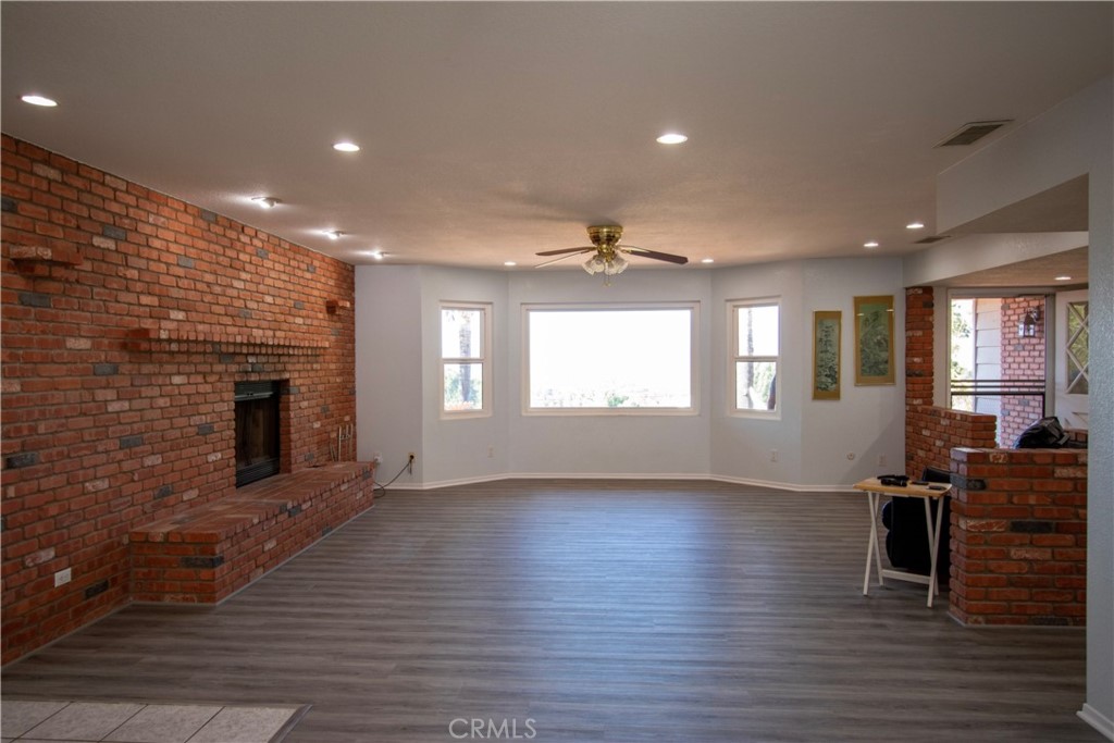 17595 Rancho De La Angel Road Ramona, CA 92065 - Photo 25 of 63 an empty room with wooden floor fireplace and windows