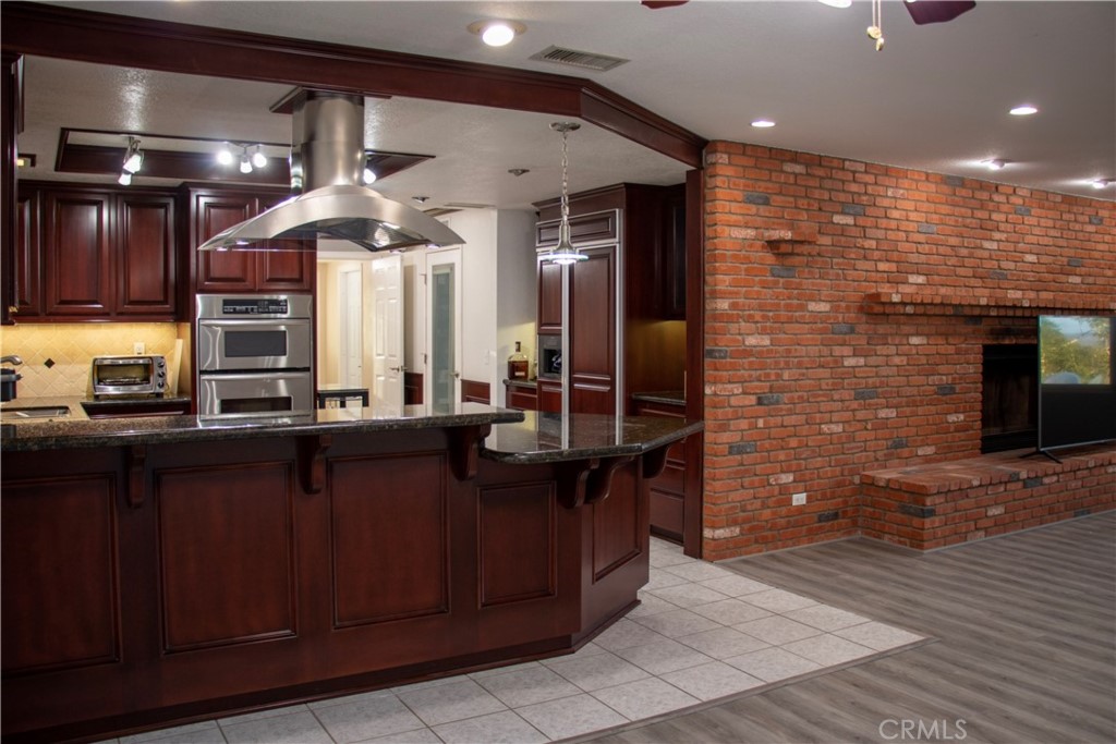 17595 Rancho De La Angel Road Ramona, CA 92065 - Photo 32 of 63 a kitchen with stainless steel appliances kitchen island granite countertop a sink counter space and cabinets