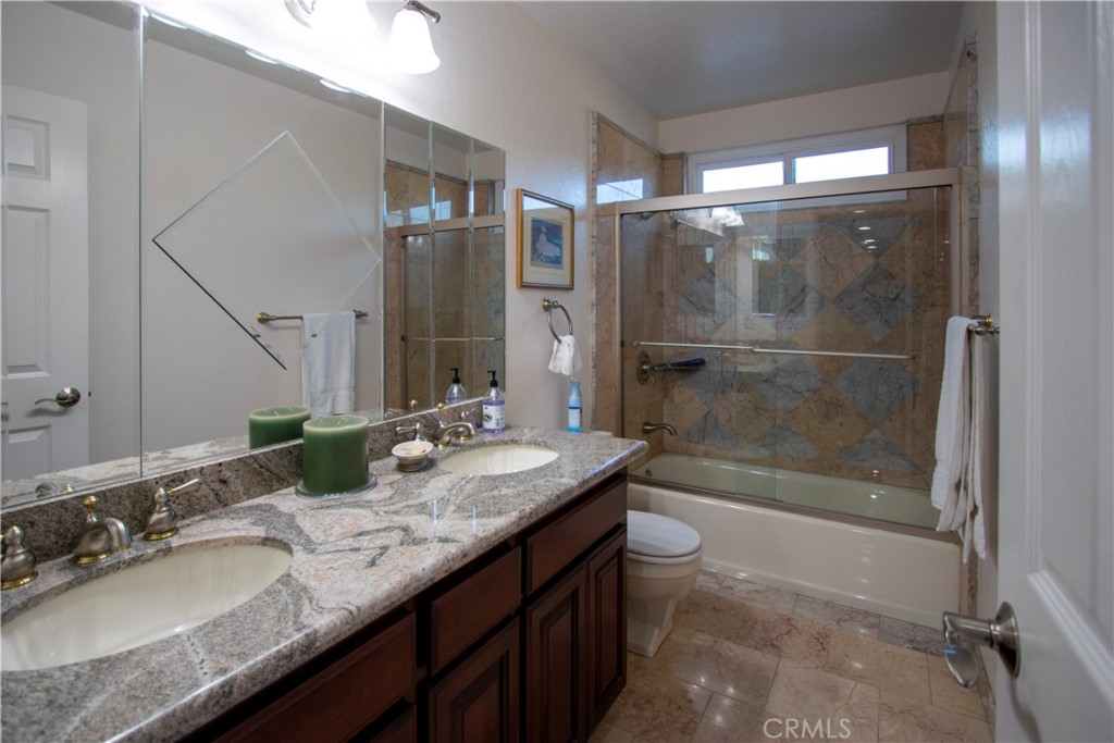 17595 Rancho De La Angel Road Ramona, CA 92065 - Photo 43 of 63 a bathroom with a granite countertop sink a toilet a mirror and shower