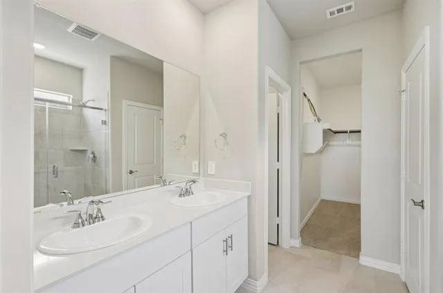 a bathroom with a double vanity sink mirror and shower
