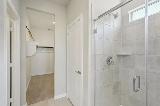 a bathroom with a shower and a glass door