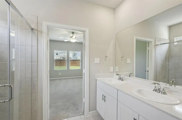 a bathroom with a shower sink and mirror