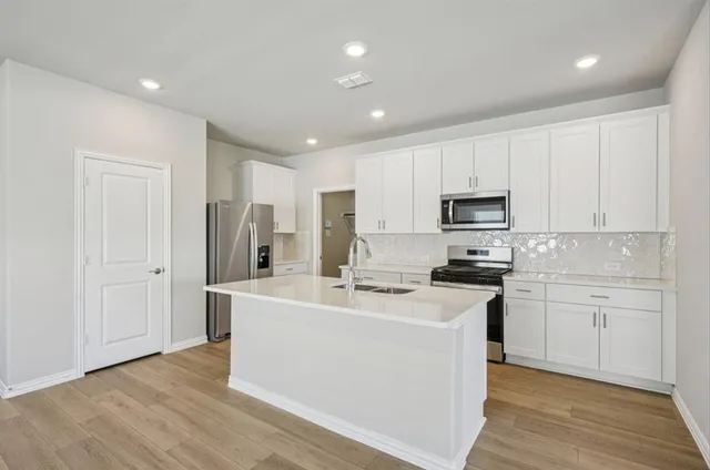 a kitchen with stainless steel appliances a white stove top oven sink and cabinets