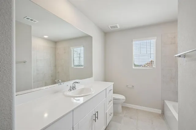 a bathroom with a granite countertop sink a toilet and a mirror