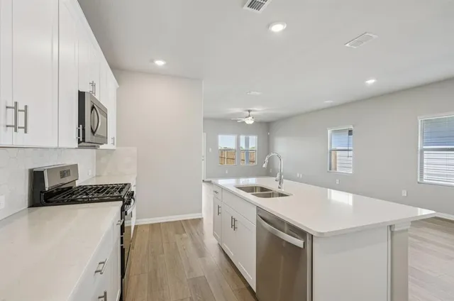 a kitchen that has a sink and a stove in it
