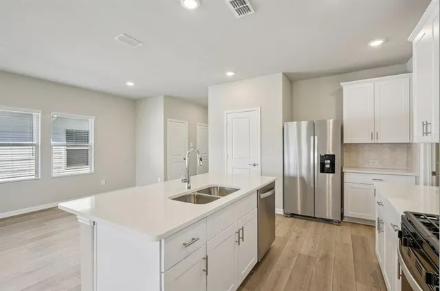 a kitchen with a sink appliances and cabinets