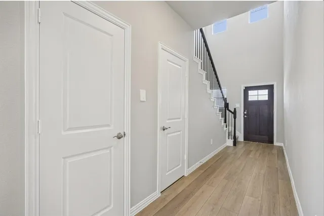 a view of a hallway with wooden floor and entryway