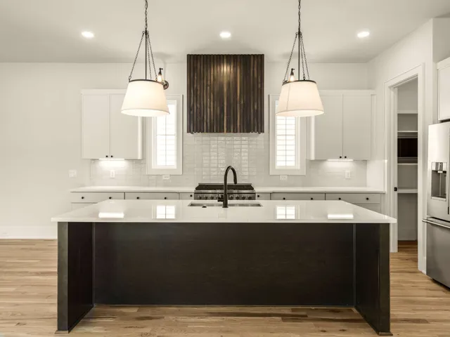 a kitchen with kitchen island granite countertop a sink a counter top space appliances and cabinets