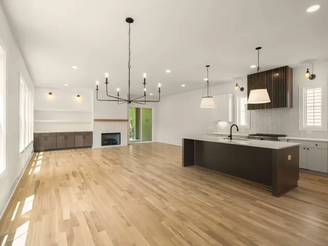 a large kitchen with kitchen island a large counter top and stainless steel appliances