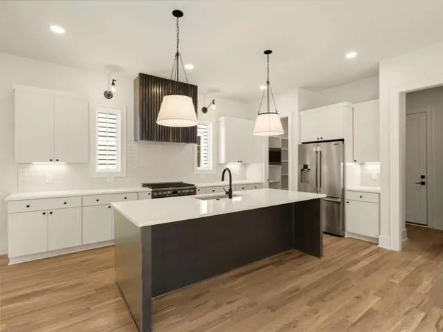 a kitchen with a sink cabinets and wooden floor