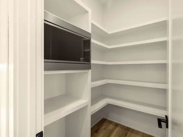 a kitchen with a stove a sink a center island with wooden floor and windows