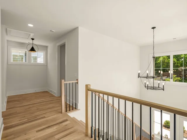 a view of a room with wooden floor and a ceiling fan
