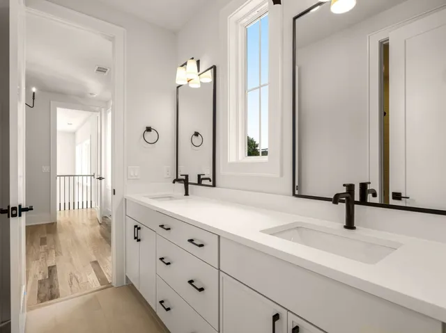 a view of a room with wooden floor ceiling fan and windows
