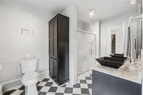 a bathroom with a sink a toilet a shower and mirror
