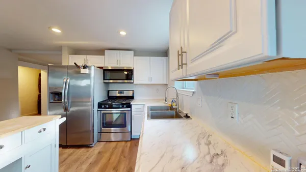 a kitchen with stainless steel appliances a stove a refrigerator and a sink