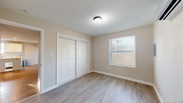 an empty room with wooden floor and a window