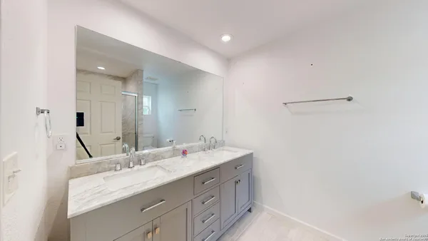 a bathroom with a double vanity sink and a mirror