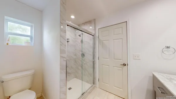 a bathroom with a shower a toilet and a sink