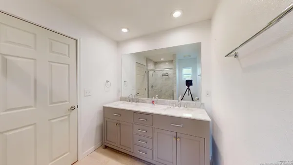 a bathroom with a double vanity sink and mirror