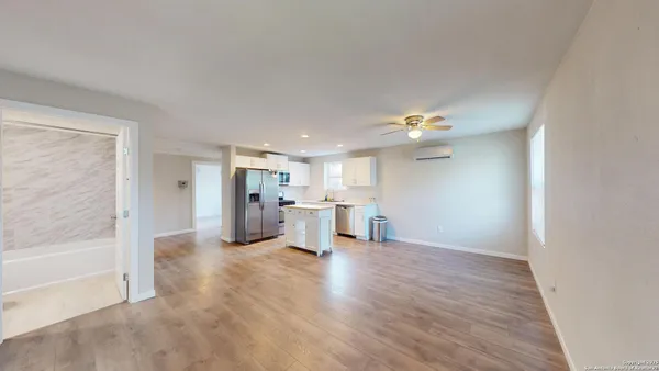 a view of a living room hardwood floor and ceiling fan