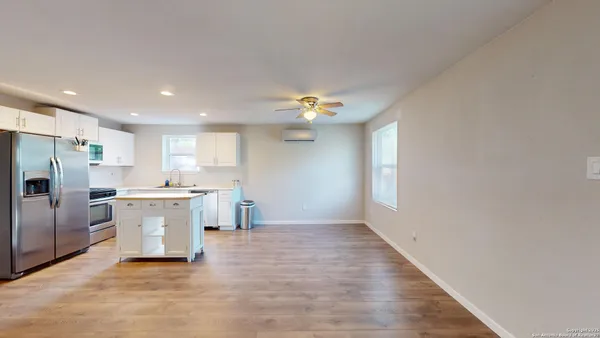 a view of a kitchen with a sink wooden floor and a window