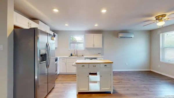 a kitchen with a refrigerator a sink and wooden floor
