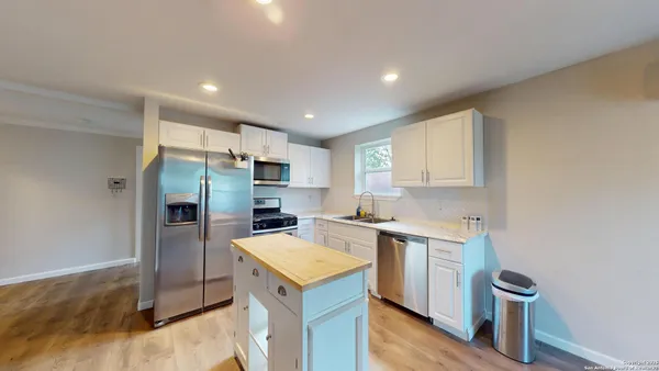 a kitchen with a sink a counter top space stainless steel appliances and cabinets