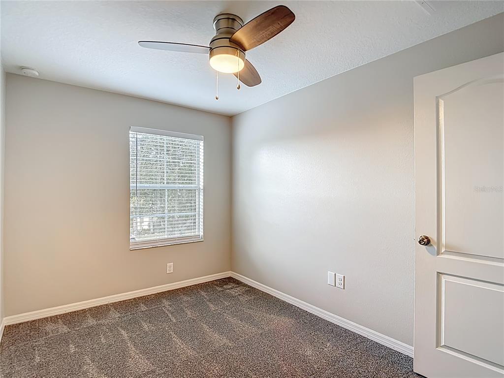 20451 Berrywood Lane Tampa, FL 33647 - Photo 48 of 57 an empty room with a window and a chandelier fan