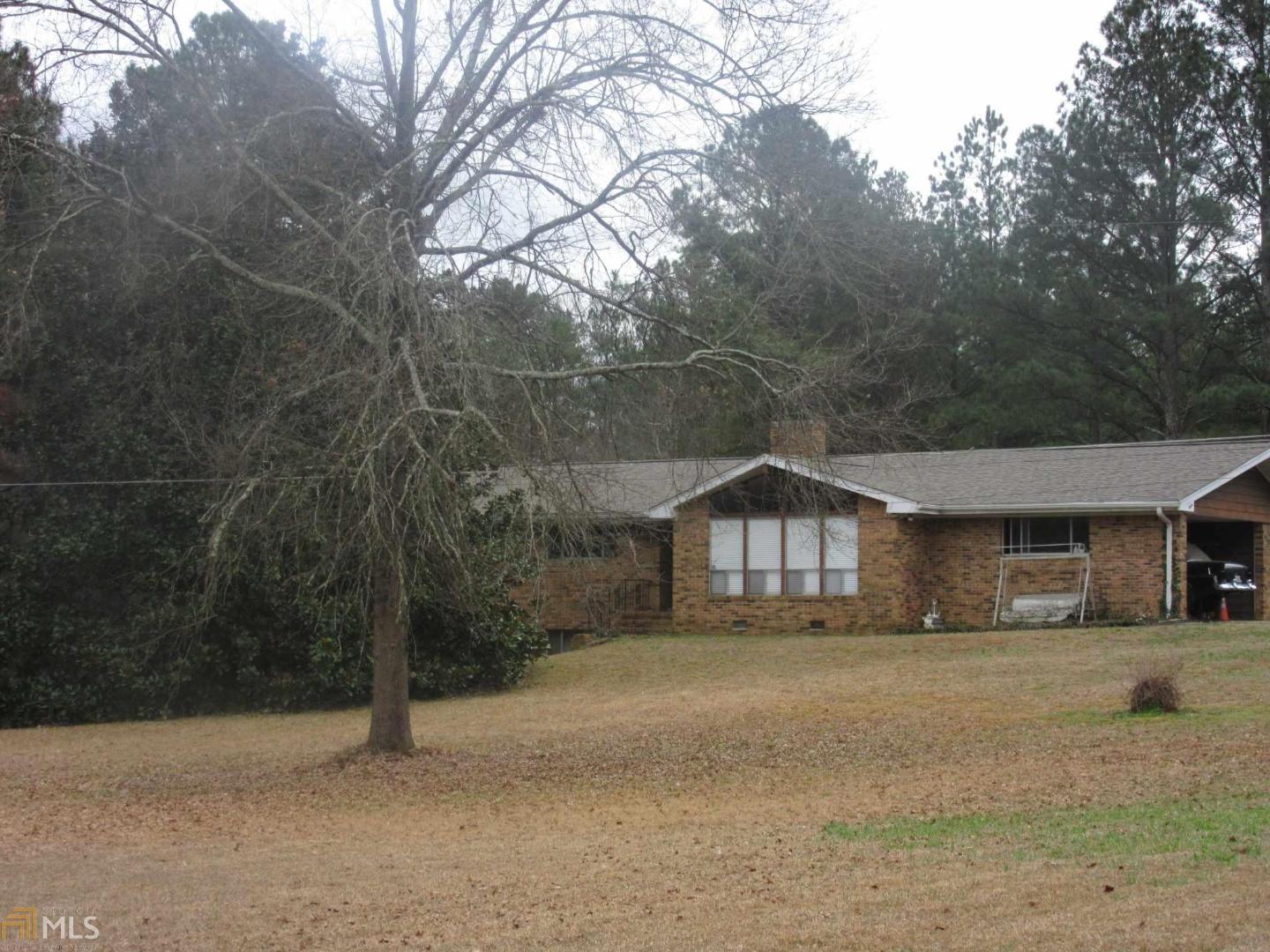 4892 Richardson Road Southwest Stockbridge, GA 30281 - Photo 1 of 1 a front view of a house with a yard and covered with trees