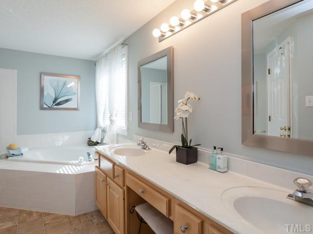 2337 Florida Court Raleigh, NC 27615 - Photo 15 of 25 The master bath offers a long vanity with dual sinks and updated mirrors wood mirrors.
