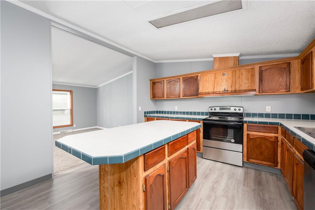 194 Andrusky Road Mercer, PA 16137 - Photo 9 of 29 a kitchen with stainless steel appliances granite countertop a stove a sink dishwasher and a microwave oven with wooden floor