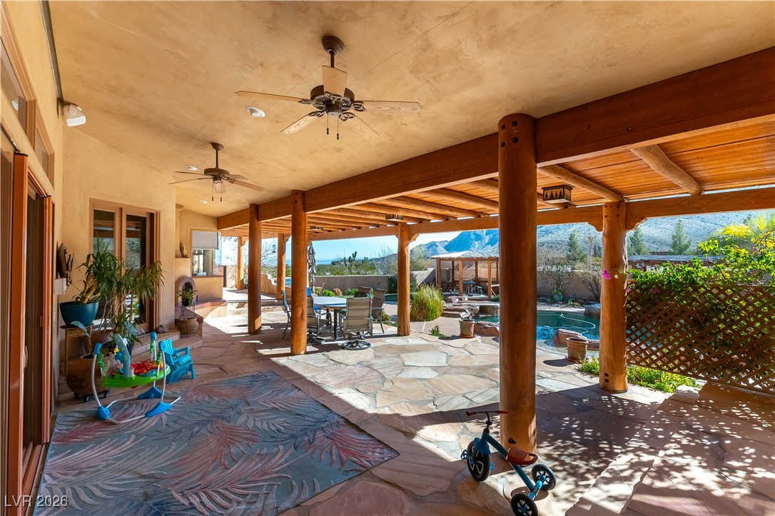 13675 Racel Street Las Vegas, NV 89166 - Photo 34 of 55 View of patio / terrace with outdoor dining area, ceiling fan, and a mountain view